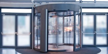 A set of silver revolving doors providing access to an office