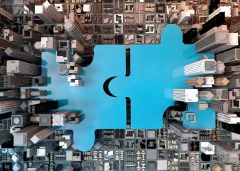 A jigsaw connecting in the middle of corporate offices symbolising the closing of a corporate acquisition