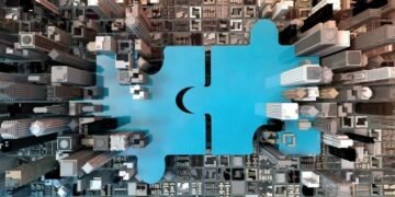 A jigsaw connecting in the middle of corporate offices symbolising the closing of a corporate acquisition