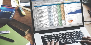 A business person using excel on a laptop to calculating marketing expenditure