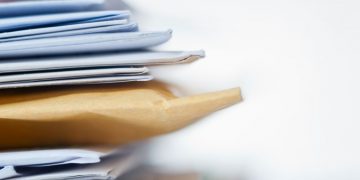 Series of marketing letters and packages with brochures that are about to be sent to prospective customers as part of a marketing campaign