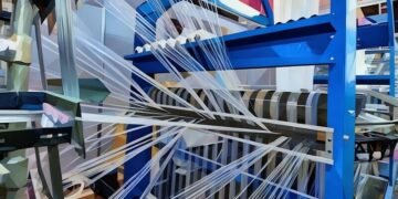 A working blue fabric loom spinning thread to be used for a clothing company