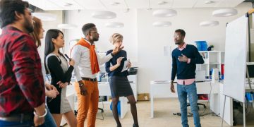 A standing meeting where a colleauge his presenting his ideas to the meeting in the form of a visual whiteboard presentation