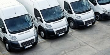 A photograph of a fleet of business white vans shot from above on a parking lot