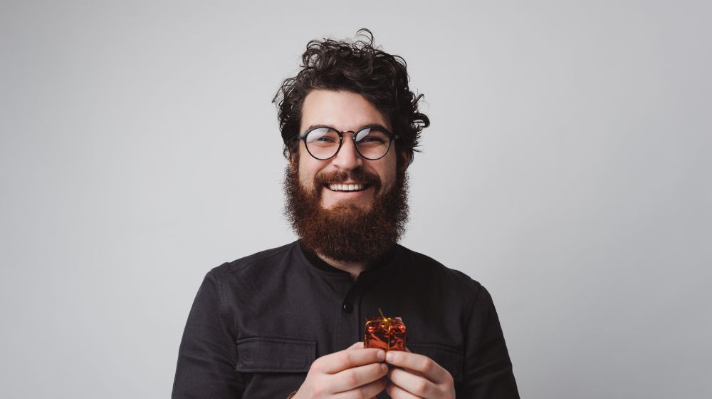 A smiling employee holding a small gift box he's been given for retirement