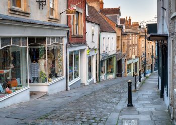 A shopping high street in an English village showing several retailers