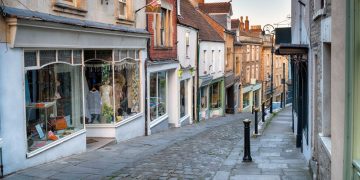 A shopping high street in an English village showing several retailers