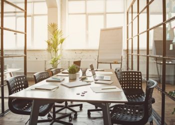 An open plan office space with a boardroom table used for creative team work