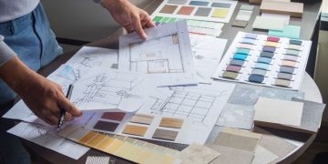 A person with sketch drawings of a new office on a table