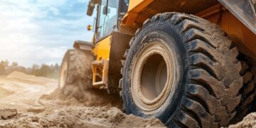 Close up on the wheel of a heavy excavator as it moves through the dirt
