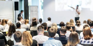 A speaker and audience at a business event in central London
