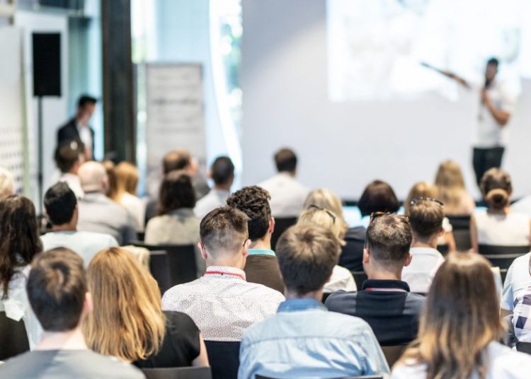 A speaker and audience at a business event in central London