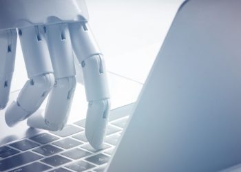 A robot hand using a laptop, symbolising how businesses can use intelligence