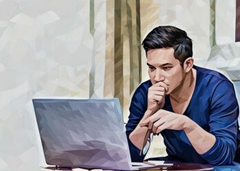 A man seriously focused on reading an article on his laptop