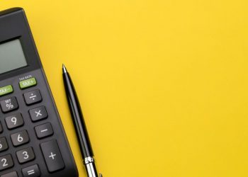 A calculator and pen on a sufrace symbolising do accounting and tax work