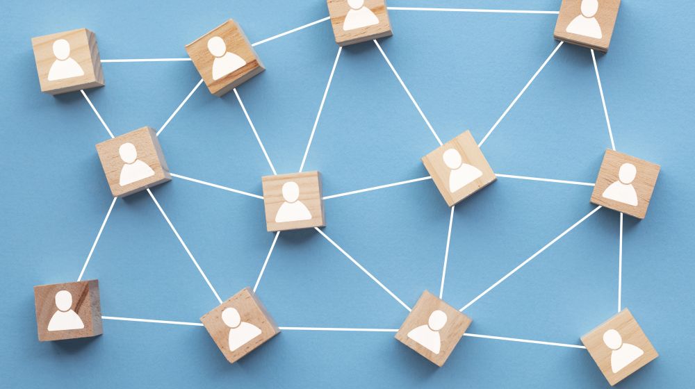 A set of wooden blocks with people sysmbols on them showing a leadership structure