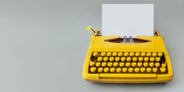 Typewriter with a blank page as an example of how difficult it can be to write the perfect offer letter