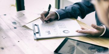 An investor and his investee using paper charts assessing the amount of relief they can obtain