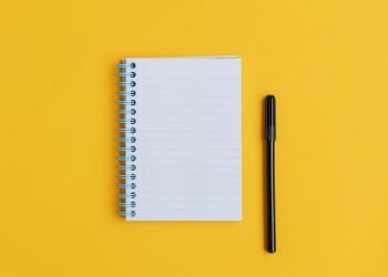 An empty notepad with a pen next to it symbolising the start of any business plan