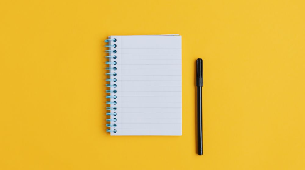 An empty notepad with a pen next to it symbolising the start of any business plan