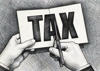 Hands cutting up paper with the word tax on, symbolising how EIS can lessen tax payable for investors