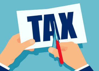 Hands cutting up paper with the word tax on, symbolising how EIS can lessen tax payable for investors