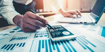 A business person using charts to assess possible finance options including loans