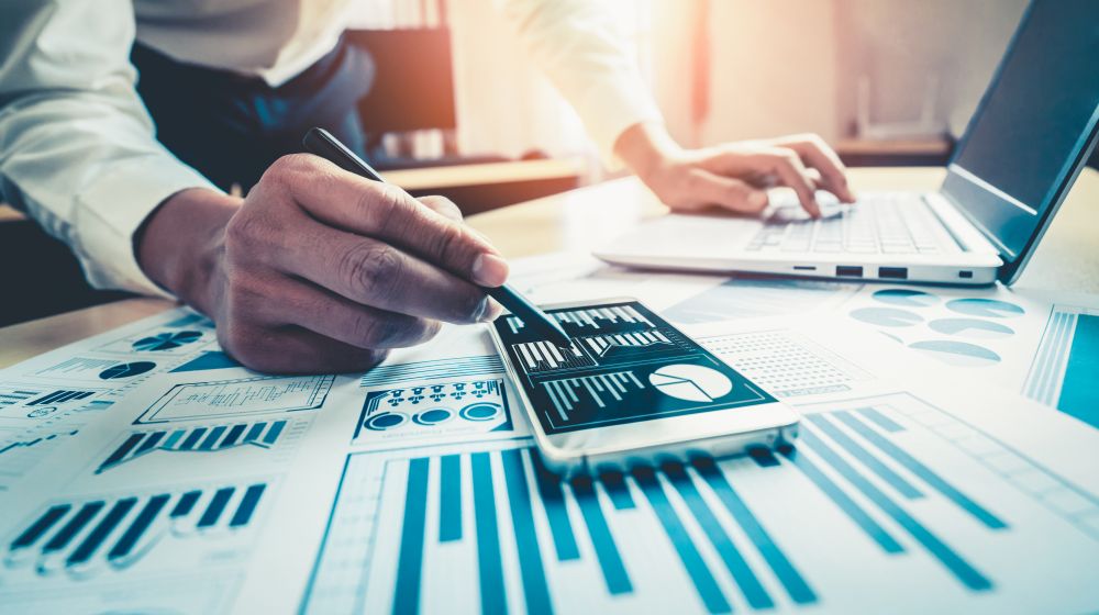 A business person using charts to assess possible finance options including loans