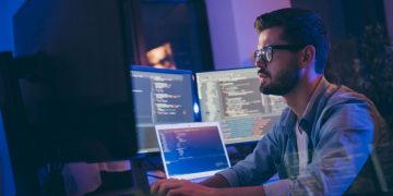 A computer programmer working at a desk on cyber security protection systems to ensure GDPR complance