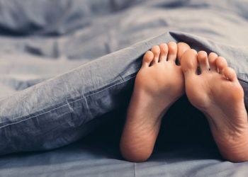 Feet poking out from underneath a weighted blanket