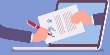 A person signing a grant application and sending it off via laptop