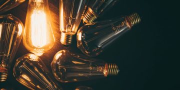 A series of light bulbs with one lit up as an example of how essential business electricity is