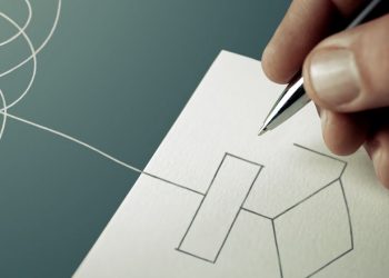 A business person drawing out processes on a piece of paper