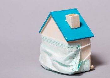 House surrounded by a face mask, as a metaphor for how COVID is affecting the property market