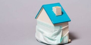 House surrounded by a face mask, as a metaphor for how COVID is affecting the property market