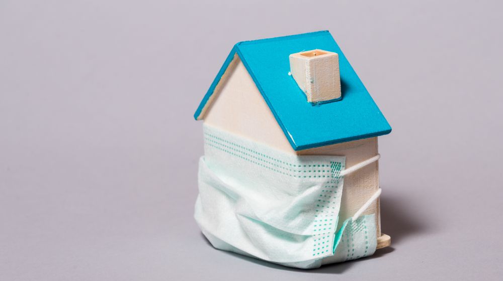 House surrounded by a face mask, as a metaphor for how COVID is affecting the property market