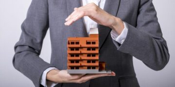 A man holding a model of a towerblock, as an example of how buy-to-let buildings insurance could protect the landlord