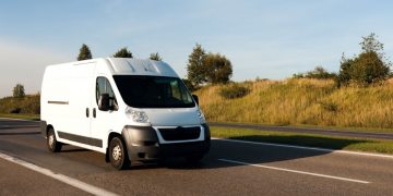A white commercial van on the road