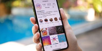 A person holding a mobile with instagram on screen