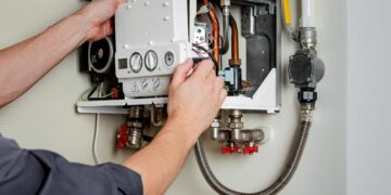 A repairman fixing a boiler that's covered by landlord boiler insurance