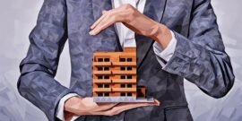 A man holding a model of a towerblock, as an example of how buy-to-let buildings insurance could protect the landlord