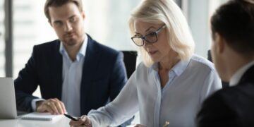 A management team with concerned looks on their faces going over a business situation that could make one one of the directors personally liable
