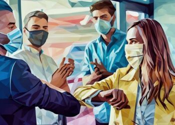 Business people wearing face masks and bumping elbows during COVID to signify closing a sales deal