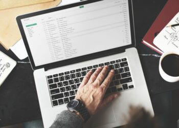 A laptop open with a business person writing an email
