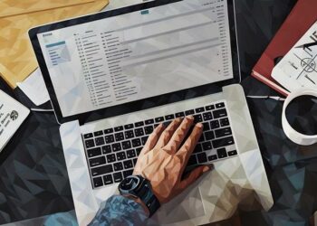 A laptop open with a business person writing an email