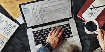 A laptop open with a business person writing an email