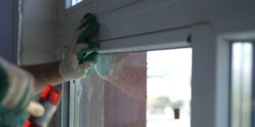 A closeup of a man replacing a sash window