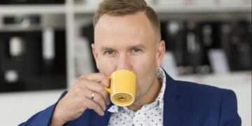 A CEO drinking coffee out of an extremely small espresso cup