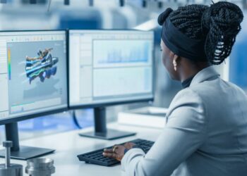 Employee sitting at a desk working on a computer being empowered and made more productive by specialist software