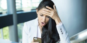 A team member staring at their phone in disbelief realising they've lost a client